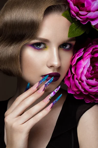 Mooi meisje met kleurrijke make-up, bloemen, retro kapsel en lange nagels. Manicure ontwerp. De schoonheid van het gezicht. — Stockfoto