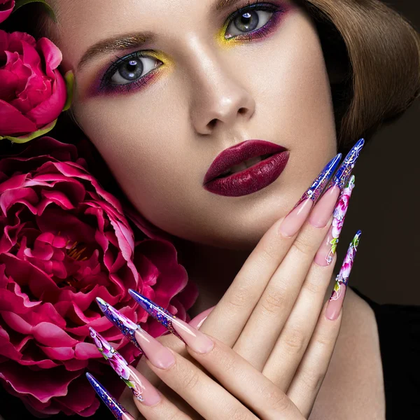 Vacker flicka med färgglada make-up, blommor, retro frisyr och långa naglar. Manikyr design. Skönheten i ansiktet. — Stockfoto