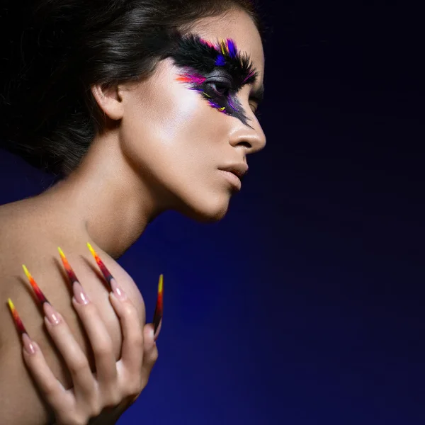 Hermosa chica en imagen de ave Fénix con maquillaje creativo y uñas largas. Diseño de manicura. cara de belleza . — Foto de Stock