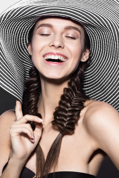 Красивая веселая девушка в полосатой шляпе на пляже. Красота лица . — стоковое фото