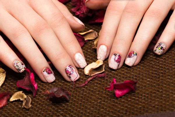 Beautiful manicure with flowers on female fingers. Nails design. Close-up — Stock Photo, Image
