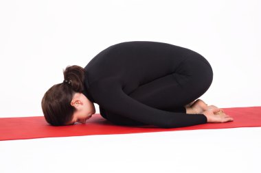 Yoga yaparken siyah elbiseli güzel atletik kız. Balasana asana çocuğun poz. Beyaz arka plan üzerinde izole.