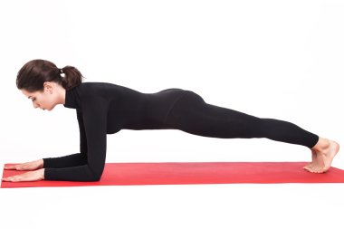 Yoga yaparken siyah elbiseli güzel atletik kız. Kumbhasana asana tahta dirsek üzerinde poz. İzole beyaz arka plan.