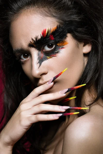 Hermosa chica en imagen de ave Fénix con maquillaje creativo y uñas largas. Diseño de manicura. cara de belleza . — Foto de Stock