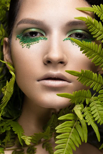 Vacker tjej med konst make-up, fern lämnar. Skönheten i ansiktet. — Stockfoto