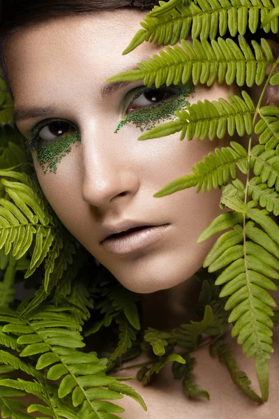 Beautiful girl with art make-up, fern leaves. The beauty of the face. Royalty Free Stock Images