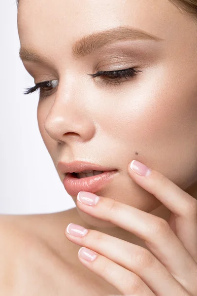 Schöne junge Mädchen mit einem leichten natürlichen Make-up und französischer Maniküre. Schönheit Gesicht. — Stockfoto