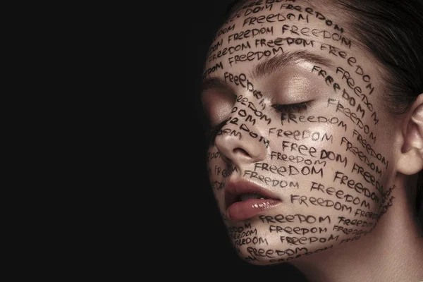 Портрет красивої жінки з намальованими словами на її обличчі. Мистецький макіяж . — стокове фото