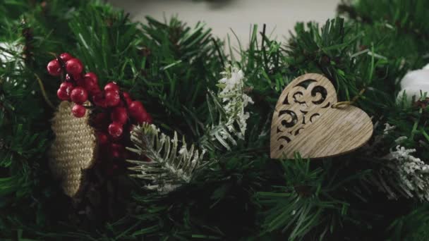 Las manos de las mujeres decoran una corona de árbol de Navidad con conos y ramas de serbal. Feliz Navidad y un feliz año nuevo — Vídeo de stock