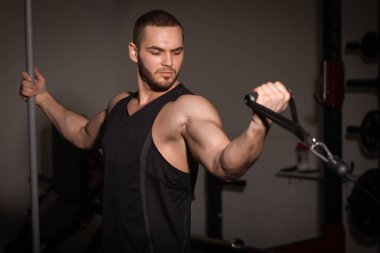 Spor salonunda spor yapan, harika karın kasları olan, siyah spor kıyafetli seksi erkekler..