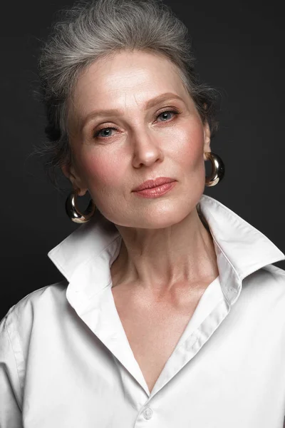 Beyaz gömlekli, güzel, yaşlı bir kadının portresi. Klasik makyaj ve gri saçlı.. — Stok fotoğraf