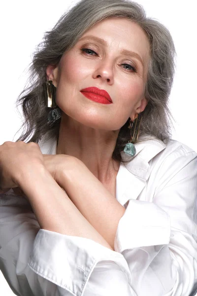 Retrato de uma bela mulher idosa em uma camisa branca com maquiagem clássica e cabelos grisalhos. — Fotografia de Stock