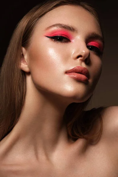 Portret van een mooie vrouw met roze creatieve make-up. Schoonheidsgezicht — Stockfoto