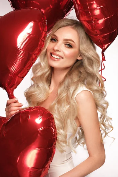 Mujer sexy en vestido blanco y globos con corazones posando en el estudio en el Día de San Valentín —  Fotos de Stock