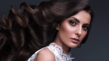 Mükemmel kıvırcık saçlı ve klasik makyajlı güzel kahverengi saçlı kız. Güzel yüz ve saç..