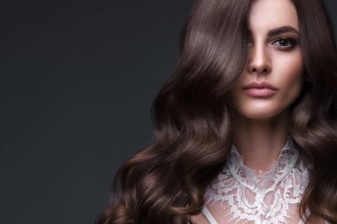 Mükemmel kıvırcık saçlı ve klasik makyajlı güzel kahverengi saçlı kız. Güzel yüz ve saç..