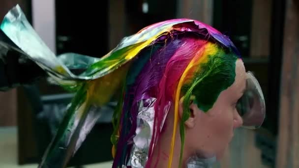 Le coiffeur teint les cheveux d'une femme blonde de différentes couleurs vives — Video