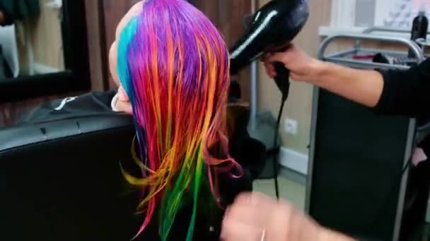 The hairdresser dyes the hair of a blonde woman in different bright colors — Stock Video