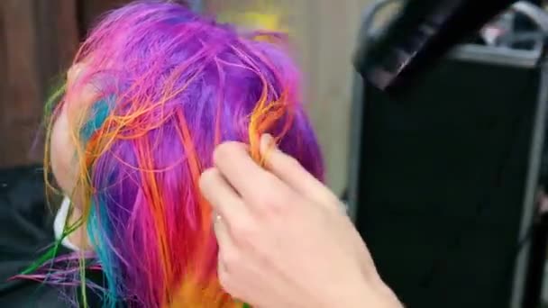 Penata rambut mewarnai rambut seorang wanita pirang dengan warna cerah yang berbeda — Stok Video