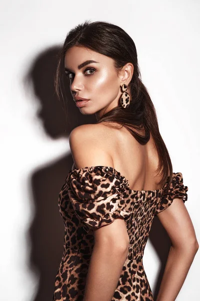 Красива сексуальна жінка в сукні з леопардом і сережками, з класичним димчастим макіяжем і модною зачіскою. Обличчя краси . — стокове фото