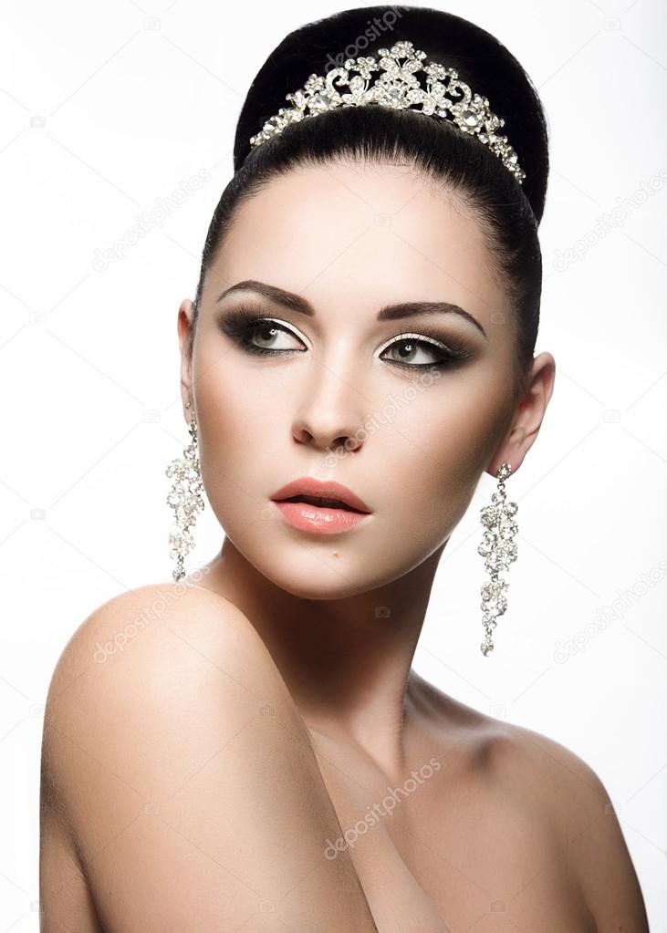 Beautiful dark-haired girl in the image of a bride with a tiara in her hair. Beauty face.