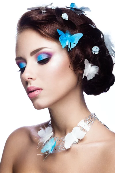 Schönes Mädchen mit leuchtend blauem Make-up und Schmetterlingen im Haar. — Stockfoto