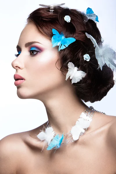 Красива дівчина з яскраво-блакитним макіяжем і метеликами в її волоссі . — стокове фото