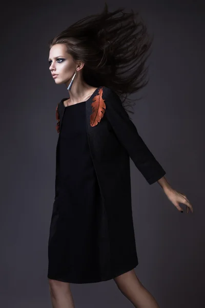Chica con estilo en una ropa de otoño de moda y maquillaje brillante con el viento en su cabello . — Foto de Stock