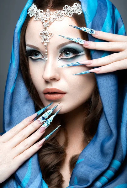 Красива дівчина в Східної Арабська зображення з довгими нігтями і яскраві сині макіяж. — стокове фото