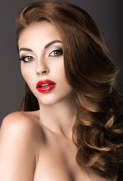 Güzel bir kadınla akşam makyaj, kırmızı dudaklar ve bukleler. Güzellik.