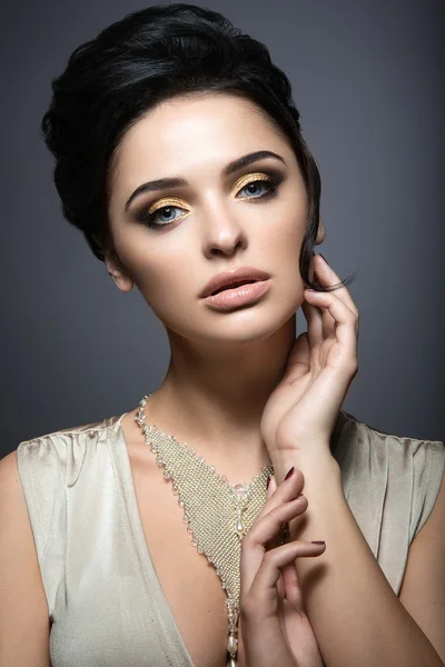 Bella donna bruna con pelle perfetta, trucco in oro e gioielli fatti a mano. Bellezza viso . — Foto Stock