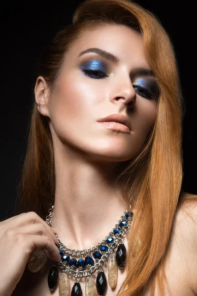 Beautiful red-haired girl with bright blue make-up and jewelry from natural stones. Beauty face. — Stock Photo, Image