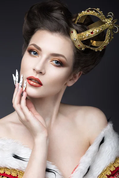 Beautiful girl in the image of the Queen in the mantle with a crown on the head and long nails. Beauty face. — Stock Photo, Image