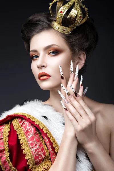 Beautiful girl in the image of the Queen in the mantle with a crown on the head and long nails. Beauty face. — Stock Photo, Image