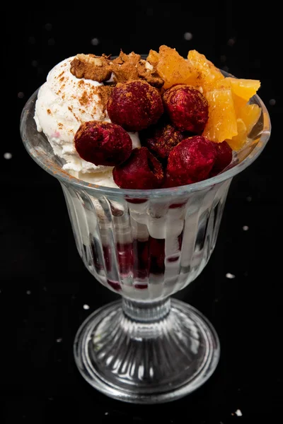 Vanilla ice cream with cranberries and cherries, oranges and walnuts. — Stock Photo, Image