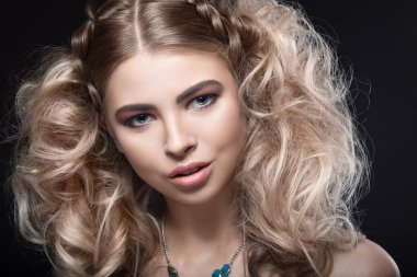 Güzel sarışın kız akşam makyaj ve örgüler ile sıradışı saç modeli ile. Güzellik.