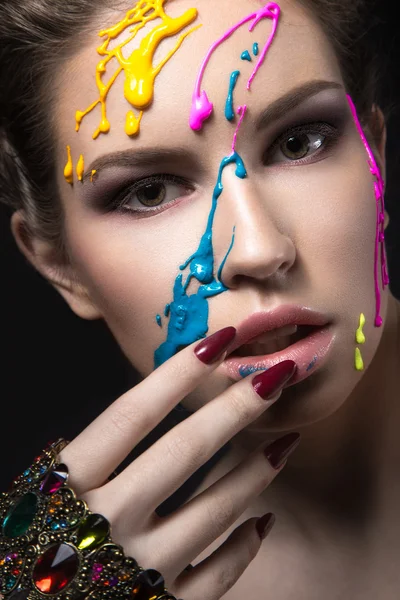 Retrato de uma linda garota com tinta colorida em seu rosto. Cara de beleza — Fotografia de Stock