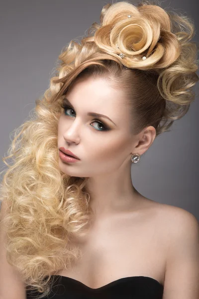 Belle fille blonde en robe de soirée avec une coiffure inhabituelle sous la forme de roses et de maquillage lumineux. Beauté visage . — Photo