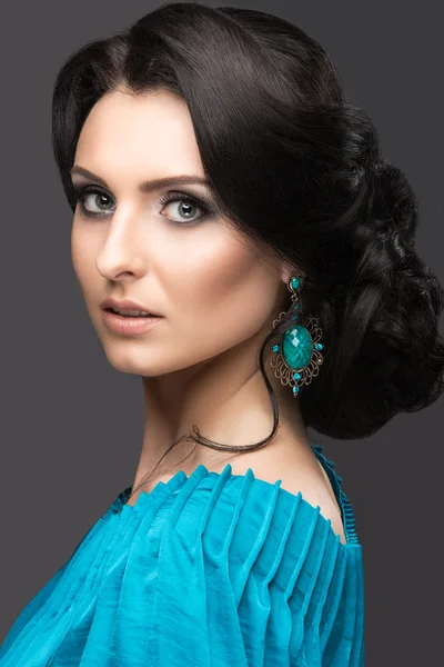 Beautiful girl in a blue dress with evening make-up and hairstyle. Beauty face. — Stock Photo, Image