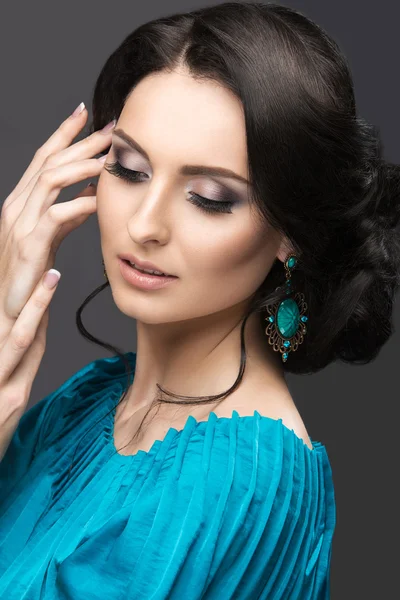 Hermosa chica en un vestido azul con maquillaje de noche y peinado. Cara de belleza . — Foto de Stock