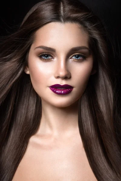 Vacker flicka med gyllene makeup och vinröda läppar med vinden i håret. Skönhet ansikte. — Stockfoto