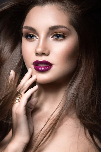 Hermosa chica con maquillaje dorado y labios borgoña con el viento en el pelo. Cara de belleza . —  Fotos de Stock