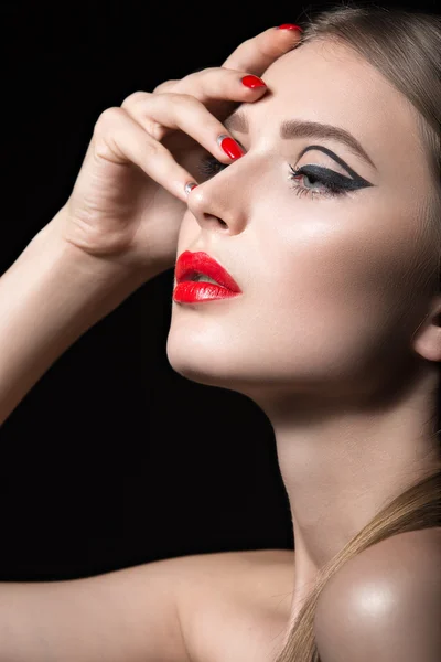 Beautiful girl with unusual black arrows on eyes and red lips and nails. Beauty face. — Stock Photo, Image