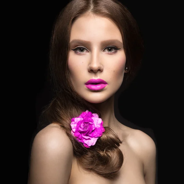 Schönes Mädchen mit rosa Lippen und einer Rose im Haar. Schönheit Gesicht. — Stockfoto