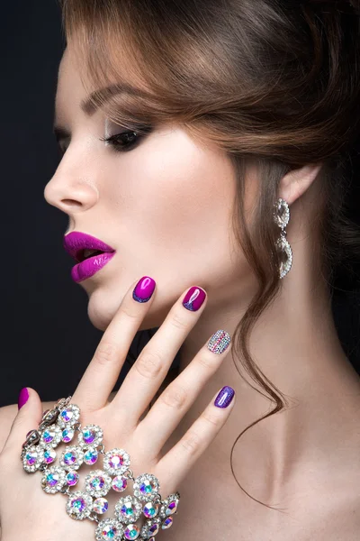 Menina bonita com uma maquiagem noite brilhante e manicure roxo com strass. Desenho de unhas. Cara de beleza . — Fotografia de Stock