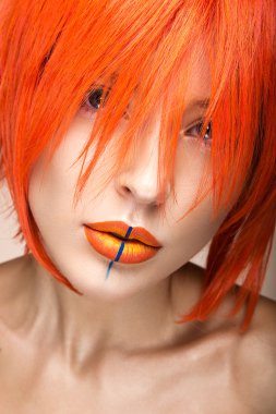 Parlak yaratıcı dudaklı portakal peruk cosplay tarzında güzel bir kız. Sanat görüntü güzellik