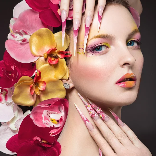 Vacker kvinna med långa naglar, perfekt hud, hår av orkidéer. — Stockfoto