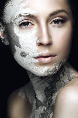 Beautiful girl with mud on his face. Cosmetic mask. Beauty face. clipart
