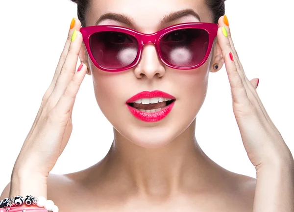 Hermosa chica en gafas de sol rojas con maquillaje brillante y uñas de colores. Cara de belleza . — Foto de Stock