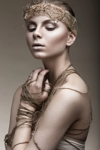 Hermosa chica con una piel de bronce, maquillaje pálido y accesorios inusuales. Arte belleza imagen. Cara de belleza . — Foto de Stock